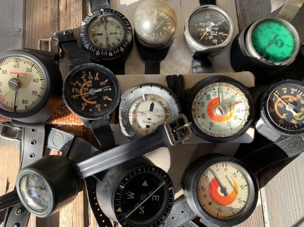 collection of divers compasses depth gauges meters